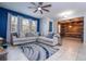 Comfortable living room with a large sectional sofa, stylish area rug, and bright blue accent wall with windows at 1139 Sand Creek Loop, Ocoee, FL 34761