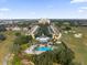 Aerial view of a resort featuring a central pool, golf course and nearby townhouses at 1338 Seven Eagles Ct # 302, Reunion, FL 34747