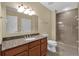 Bathroom with granite counters, wood cabinets and a glass enclosed shower at 1338 Seven Eagles Ct # 302, Reunion, FL 34747