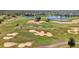 Aerial view of a lush golf course featuring sand traps and a water feature at 1338 Seven Eagles Ct # 302, Reunion, FL 34747