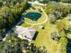 Expansive aerial view of home featuring circular drive, private pond with fountain and lush landscaping at 1780 Old Mission Rd, Edgewater, FL 32132