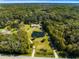 Aerial view of home on sprawling lot featuring lush landscaping, mature trees and private pond at 1780 Old Mission Rd, Edgewater, FL 32132