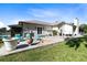 Back patio with outdoor seating, fire pit, and lush green lawn, perfect for relaxation at 1780 Old Mission Rd, Edgewater, FL 32132