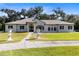 Charming single-story home featuring a well-manicured lawn, dark shutters and stately urns at 1780 Old Mission Rd, Edgewater, FL 32132