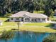 Stunning single-story home featuring a tranquil pond with fountain, lush landscaping and mature trees at 1780 Old Mission Rd, Edgewater, FL 32132