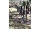 Image shows a black mesh fence with painted wooden posts in a yard with scattered grass and leaves at 1780 Old Mission Rd, Edgewater, FL 32132