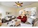 Inviting living room featuring comfortable sofas, decorative pillows, ceiling fan, and view into kitchen at 1780 Old Mission Rd, Edgewater, FL 32132