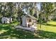 Charming playhouse on a well-maintained lawn, complemented by mature trees and lush greenery at 1780 Old Mission Rd, Edgewater, FL 32132