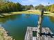 Scenic view of a large pond with a fountain, seen from a wooden dock with a rustic lift mechanism at 1780 Old Mission Rd, Edgewater, FL 32132