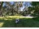 A green lawn leads to parked trucks and swing under large shady trees draped in Spanish moss at 1780 Old Mission Rd, Edgewater, FL 32132