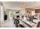 Bright dining area with a glass-top table, modern chairs, and natural light, adjacent to an open living space at 1839 Waggoner St, Kissimmee, FL 34744