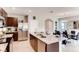 Modern kitchen featuring granite countertops, stainless appliances, dark wood cabinetry, and island with barstool seating at 1839 Waggoner St, Kissimmee, FL 34744