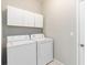 Well-lit laundry area equipped with a washer, dryer, and overhead storage cabinets at 1870 Bridgeview Cir, Orlando, FL 32824