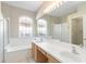 Spacious main bathroom features a long vanity with double sinks, soaking tub, shower, and a large mirror at 1870 Bridgeview Cir, Orlando, FL 32824