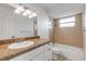 Bathroom featuring a granite countertop, tiled shower and bathtub combination, and vanity mirror at 2130 Pope Ave, South Daytona, FL 32119