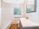 Clean bathroom featuring white tiled walls, modern fixtures, and wood-look tile floor at 2394 Orange Center Blvd, Orlando, FL 32805