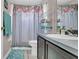 Cozy bathroom featuring a floral shower curtain and vanity with ample storage at 2417 Hybrid Dr, Kissimmee, FL 34758