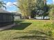 A lush backyard with trees and a glimpse of the lake behind the house at 2602 Talon Ct, Orlando, FL 32837