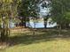 A view of the backyard with a treeline and a view of the lake beyond at 2602 Talon Ct, Orlando, FL 32837