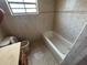 Traditional bathroom featuring a tub, beige tile and a toilet, offering a functional design at 2602 Talon Ct, Orlando, FL 32837