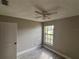 A cozy bedroom showcasing neutral walls, light wood floors, a ceiling fan, and a bright window at 2602 Talon Ct, Orlando, FL 32837