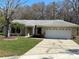 Charming single-story home with well-manicured lawn, mature trees, and a two-car garage at 2602 Talon Ct, Orlando, FL 32837