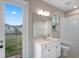 Bathroom with a white vanity, tub and shower combo, and view of the backyard at 2620 Cedar Shake Ct, Oviedo, FL 32765