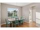 Cozy dining room with modern table set, hardwood floors, and natural light from a large window at 2620 Cedar Shake Ct, Oviedo, FL 32765