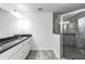 Bathroom featuring granite vanity top, chrome fixtures, walk-in shower, and tile flooring at 280 Marion Oaks Golf Way, Ocala, FL 34473