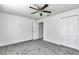 Bedroom features neutral carpet, ceiling fan, closet and view to the hallway at 280 Marion Oaks Golf Way, Ocala, FL 34473