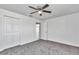 Bedroom features neutral carpet, ceiling fan, closet and view to the hallway at 280 Marion Oaks Golf Way, Ocala, FL 34473