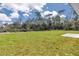 A view of the expansive green backyard with trees and a concrete pad at 2844 Sw 162Nd Street Rd, Ocala, FL 34473