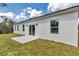 A modern white home exterior with a backyard concrete patio and sliding glass doors at 2844 Sw 162Nd Street Rd, Ocala, FL 34473