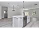 Spacious kitchen island with sink, stainless steel dishwasher, and modern faucet, with an open view of the living area at 2844 Sw 162Nd Street Rd, Ocala, FL 34473