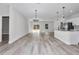 Bright and airy living room showcasing modern lighting fixtures, plank flooring, and an open layout with access to the kitchen at 2844 Sw 162Nd Street Rd, Ocala, FL 34473