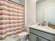 Cozy bathroom featuring a tub and shower combination with a striped shower curtain and neutral colored vanity at 2908 Protagonist St, Kissimmee, FL 34746