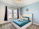 Bright bedroom featuring queen bed with white frame, blue bedding, and decorative pillows at 2908 Protagonist St, Kissimmee, FL 34746