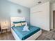 Bedroom with blue accent wall, white queen bed, and closet with folding doors at 2908 Protagonist St, Kissimmee, FL 34746