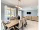 Elegant dining area with seating for eight, modern lighting, and views of the pool area through sliding glass doors at 2908 Protagonist St, Kissimmee, FL 34746