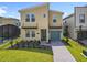 Modern two-story home featuring desert-tone walls, manicured lawn, stone accents, and attached garage at 2908 Protagonist St, Kissimmee, FL 34746