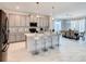 Bright, open kitchen with gray cabinets, marble tile floors, stainless steel appliances, and adjacent dining area at 2908 Protagonist St, Kissimmee, FL 34746
