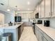 Well-equipped kitchen featuring gray cabinets, quartz countertops, black appliances, and a functional layout at 2908 Protagonist St, Kissimmee, FL 34746