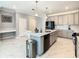 Spacious kitchen with light gray cabinets, quartz countertops, island, black appliances, and open layout at 2908 Protagonist St, Kissimmee, FL 34746