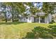 A large green lawn in backyard extends from the home to shady mature trees at 2935 Willow Bay Ter, Casselberry, FL 32707