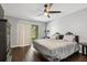 Bedroom features a queen bed, dark wood floors, and sliding glass doors at 3151 Britannia Blvd # A, Kissimmee, FL 34747