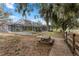 Home exterior features an enclosed pool area, spacious backyard, picnic table, and wooded area at 37224 Apiary Rd, Grand Island, FL 32735