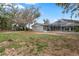 Expansive backyard with gray home, screened-in pool enclosure, and partially grass and bare ground at 37224 Apiary Rd, Grand Island, FL 32735