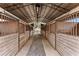 Interior view of barn aisleway, stalls, and open-air structure for natural light and ventilation at 37224 Apiary Rd, Grand Island, FL 32735