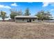 View of the barn with slider door and metal roof surrounded by a fenced enclosure on a sunny day at 37224 Apiary Rd, Grand Island, FL 32735