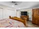 Comfortable bedroom with wood-look flooring, a wooden bed frame, and natural light streaming through the window at 37224 Apiary Rd, Grand Island, FL 32735